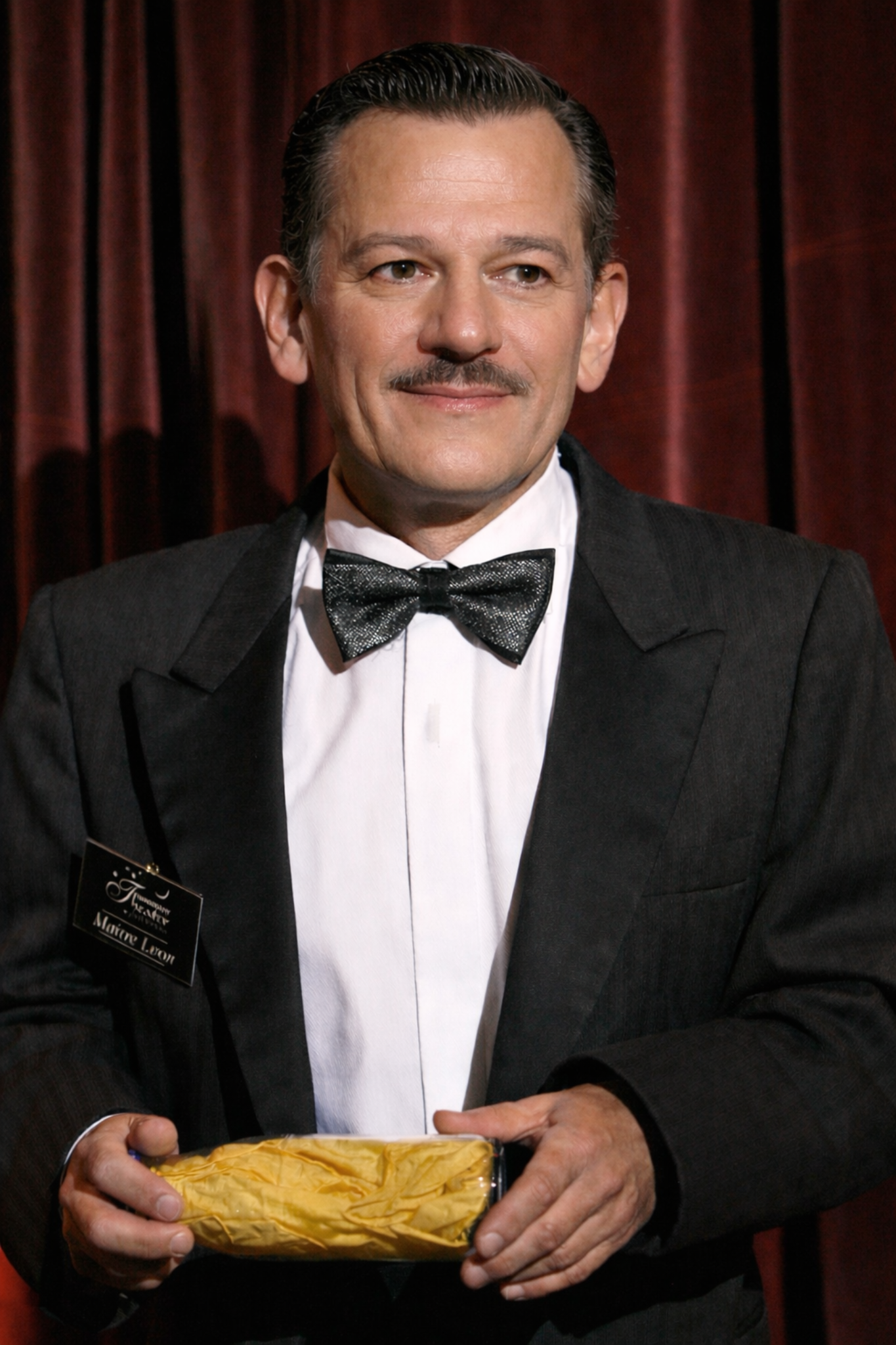 Porträt von Roland Schopp vor rotem Vorhang